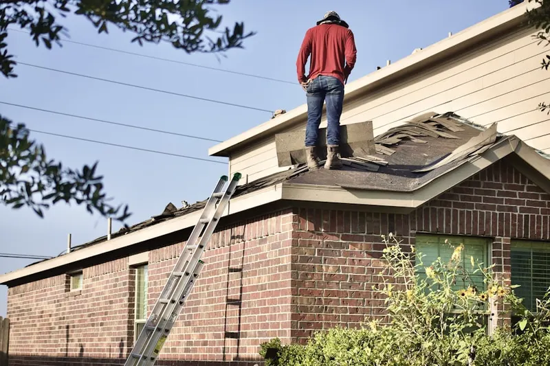 Professional roofer working on a residential roof in Penrose